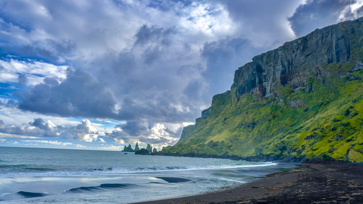 Black sand beach and green cliffs in Vik, Iceland, displayed as ambient TV content